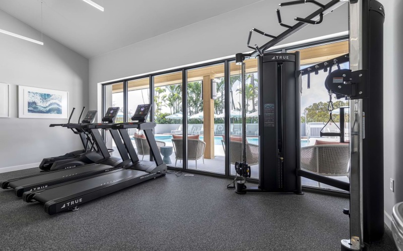 a gym with exercise equipment and large windows