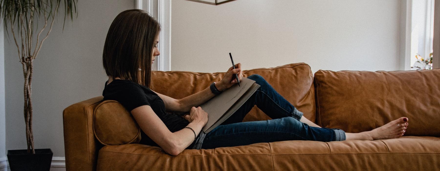 a person sitting on a couch writing